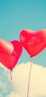 Red heart-shaped balloons float in a clear blue sky with fluffy clouds.