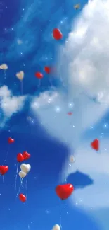 Red heart balloons floating in blue sky with clouds.