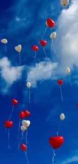 Heart-shaped balloons float in a clear blue sky.