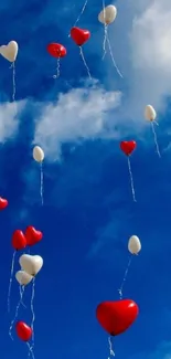 Heart-shaped balloons floating in a bright blue sky.