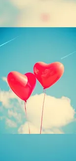 Heart-shaped balloons float against a blue sky with fluffy clouds.