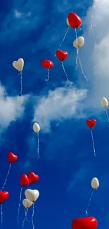 Heart-shaped balloons float in a blue sky.