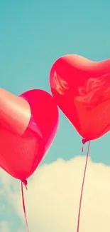 Red heart-shaped balloons float against a blue sky.