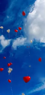 Heart-shaped balloons floating in a vibrant blue sky.