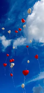 Heart balloons float in a vibrant blue sky with clouds, creating a cheerful scene.