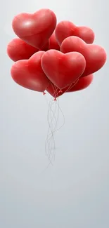 Heart-shaped balloons floating in mid-air on a mobile wallpaper background.