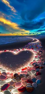 Heart-shaped sand, colorful stones, and sunset glow on a beach.