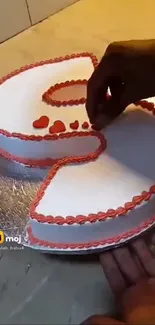 Heart-shaped cake with red icing decoration.