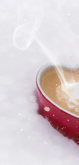 Heart-shaped coffee cup on snowy ground.