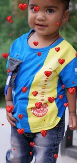 Cute toddler with hearts on blue shirt.