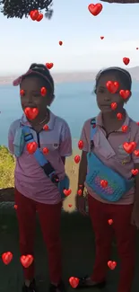 Two smiling children with hearts against a lakeside view.