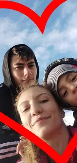 A heart-framed family photo under a vibrant blue sky.