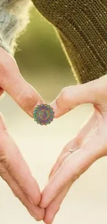 Hands forming a heart with a colorful mandala in the center.