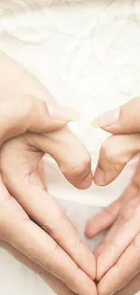 Hands form a heart on a lace wedding dress, symbolizing love and elegance.