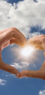 Hands forming heart with sky and sunlight background.