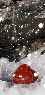 Red heart on snowy landscape with rocks and ice.