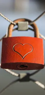 Close-up of a heart-engraved red lock on a fence, symbolizing love and security.