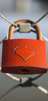 Red heart-engraved padlock on wire mesh background.