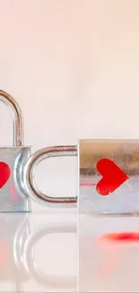 Two shiny padlocks with red hearts on a reflected surface.