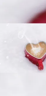 Heart-shaped mug in snowy background with steam rising.