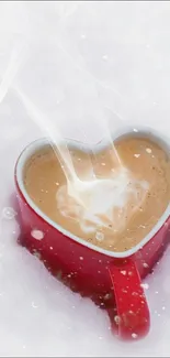 Heart-shaped coffee mug in snow with steam rising.