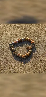 Heart-shaped stone arrangement on sandy beach scene.