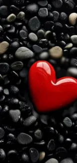 Red heart on black pebbles wallpaper for mobile. Perfect for romantic themes.