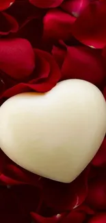 Heart-shaped object on red rose petals wallpaper.