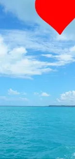 A red heart floats above a peaceful tropical ocean scene with blue sky.