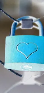 Blue padlock with heart design on chain fence.