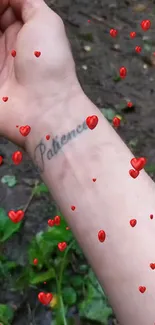 Arm with 'Patience' tattoo surrounded by floating red hearts.