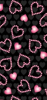 Pink hearts pattern on black wallpaper.