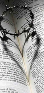 Heart shadow on an open book with crown of thorns.
