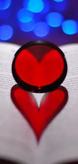 Heart-shaped shadow from a book with blue bokeh background.