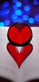 Red heart shape reflected on an open book with vibrant bokeh background.