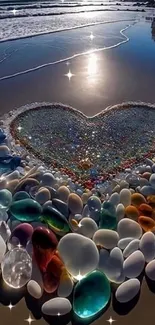 Heart-shaped arrangement of colorful stones on a sandy beach at sunrise.