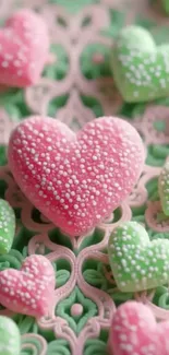 Heart-shaped candies in pink and green on a decorative surface.
