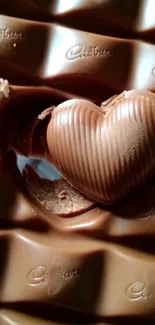 Heart-shaped chocolate on brown chocolate bar.