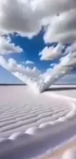 Heart-shaped cloud in a blue sky over sand.