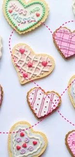 Heart cookies with pink and pastel icing on a white background.