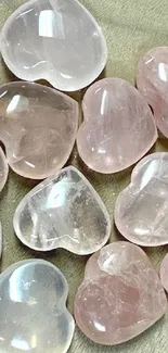 Heart-shaped rose quartz crystals on wood surface.