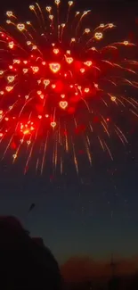 Heart-shaped fireworks light up the night sky in vibrant red.
