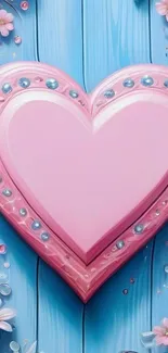 Heart-shaped pink floral design on blue background with flowers.