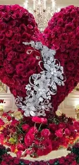 Heart-shaped bouquet of red roses with silver accents in an elegant setting.