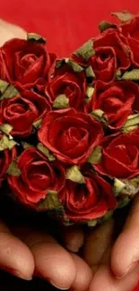 Heart-shaped red rose bouquet held in hands.