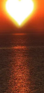 Heart-shaped sunset over ocean with orange sky reflection.