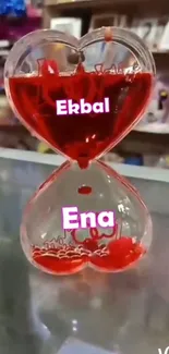 Heart-shaped glass timer with red liquid.