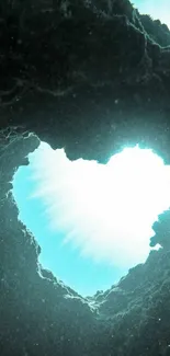 Heart-shaped underwater cave with sunlight streaming through aqua blue water.