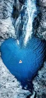 Heart-shaped pool with waterfall in a rocky landscape.