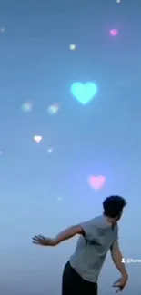 Man gazing at heart-shaped lights in blue sky wallpaper.